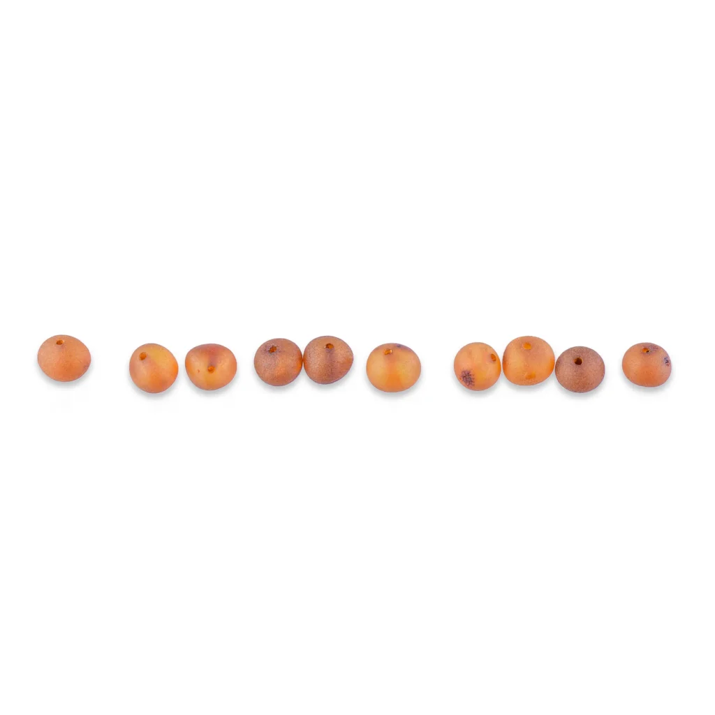 Handmade Baltic amber beads in a rich cognac color, arranged in a smooth, gradient row.