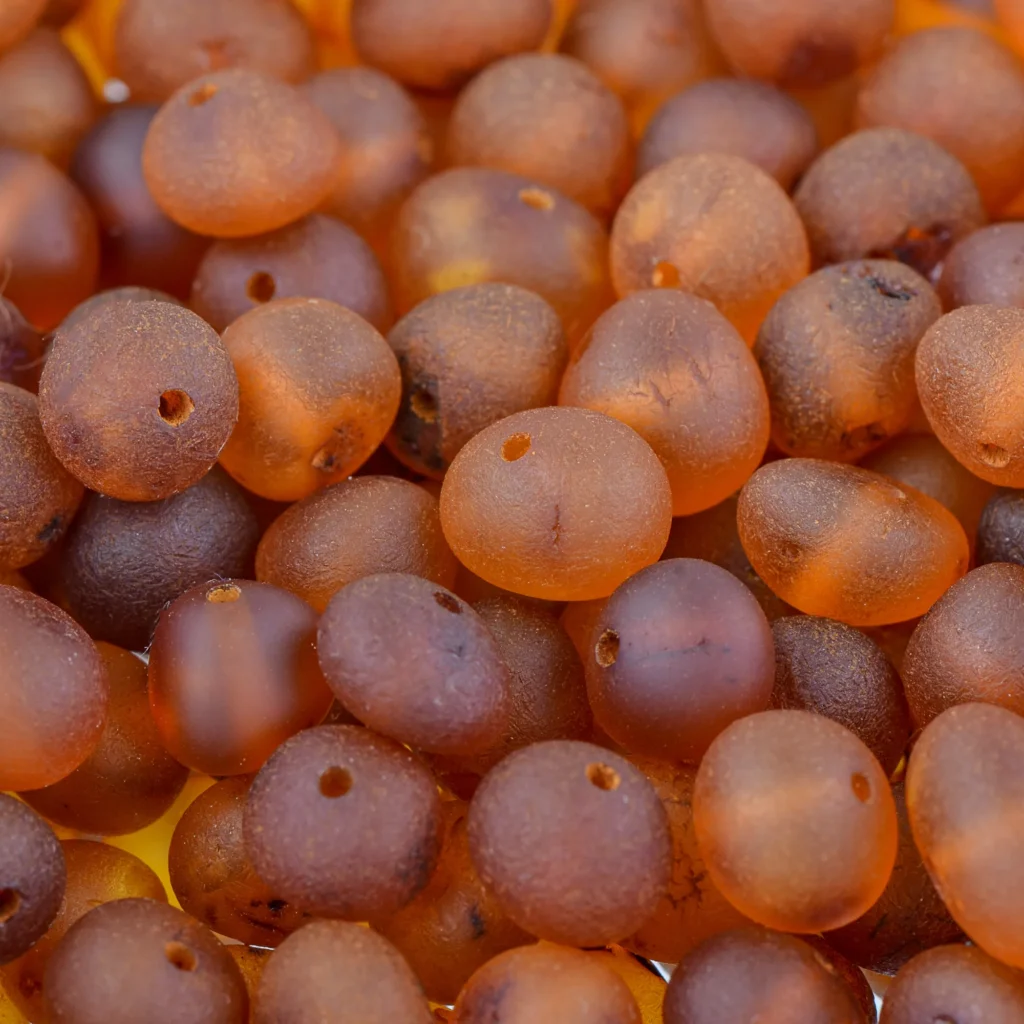 Natural Baltic amber beads in warm cognac tones with glossy, organic-centered design.