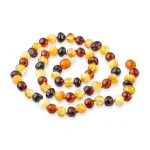 Elegant handmade Baltic amber necklace with multicolor, warm-toned, glossy beads in organic shapes.