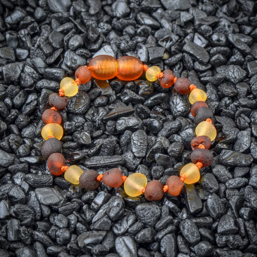Colorful amber and dark bead bracelet on black stones, handcrafted elegant jewelry accessory.