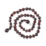 Handmade Baltic amber necklace with natural reddish-brown beads, elegant and versatile jewelry piece.