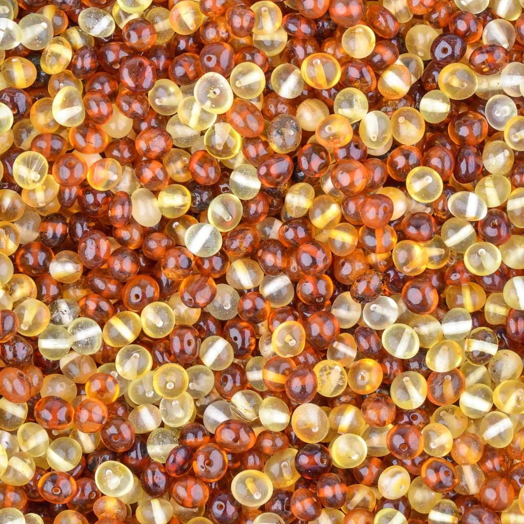 Close-up of glossy amber beads in warm honey and golden tones, highlighting natural craftsmanship.