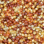 Close-up of glossy amber beads in warm honey and golden tones, highlighting natural craftsmanship.
