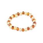 Handcrafted Baltic amber beaded bracelet with warm amber and cream tones on elastic stretch.