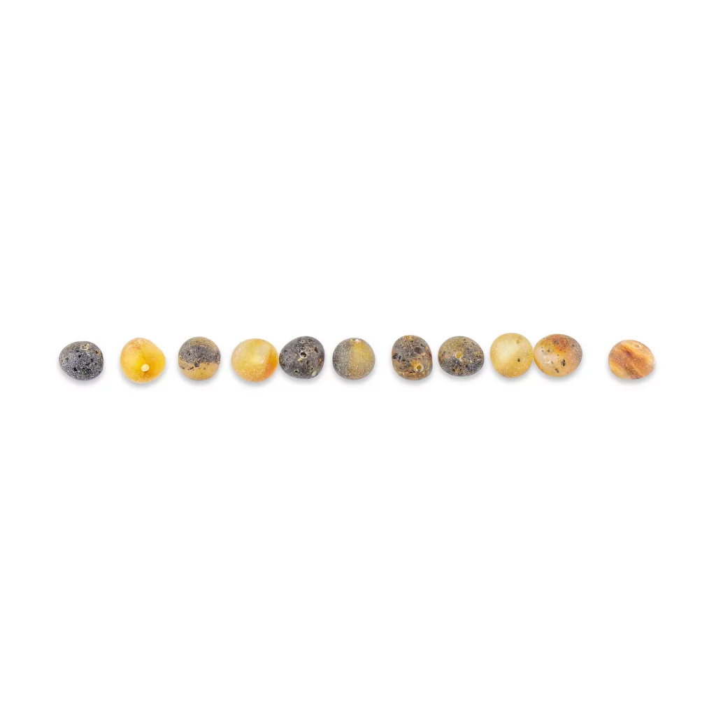 Collection of polished amber beads in warm earth tones, ideal for jewelry or crafts.