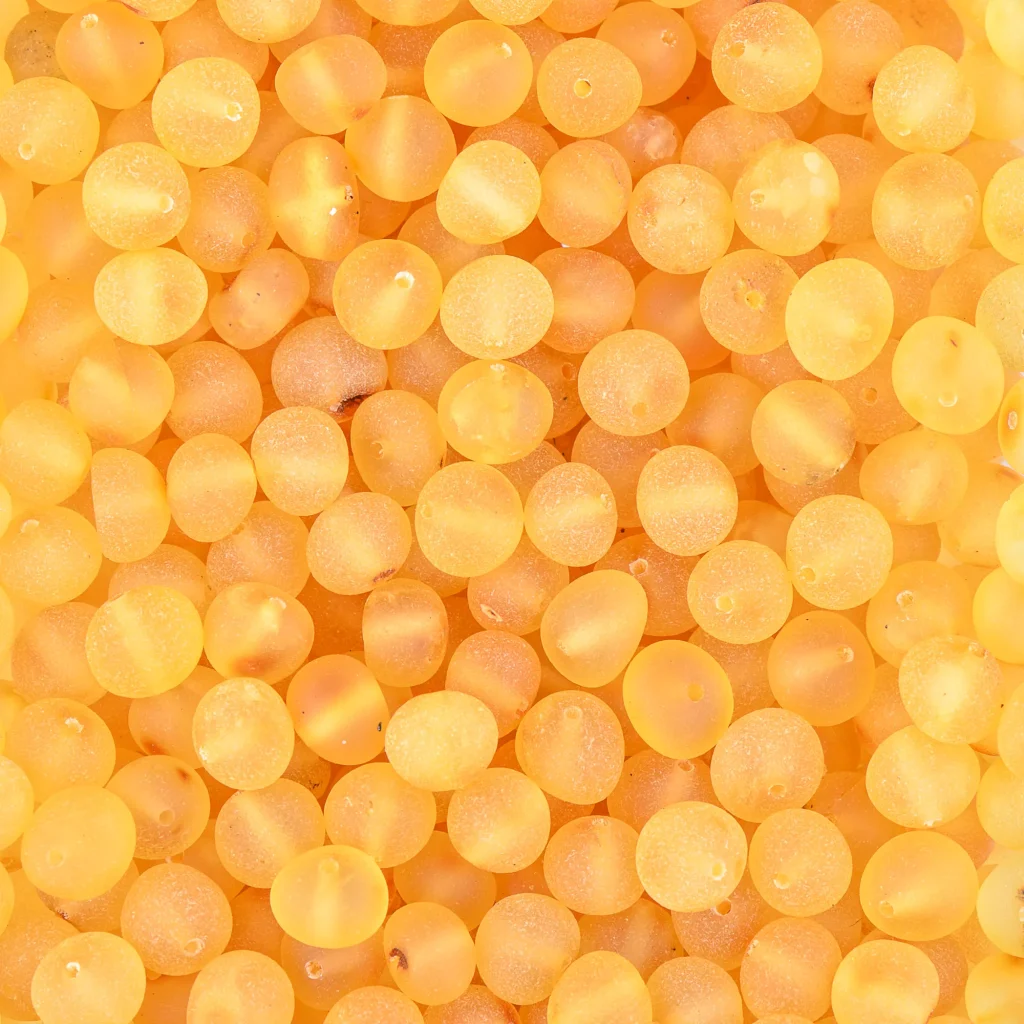 Close-up of warm amber beads with a glowing, translucent, honey-colored finish.