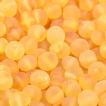 Close-up of textured, honey-colored amber beads with matte finish and organic irregularities.