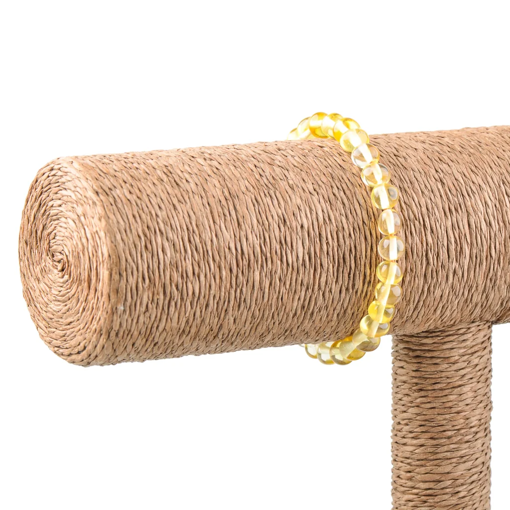 Rustic sisal-covered post with bright yellow beaded bracelet, blending natural texture and cheerful decor.
