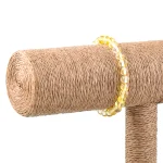 Rustic sisal-covered post with bright yellow beaded bracelet, blending natural texture and cheerful decor.