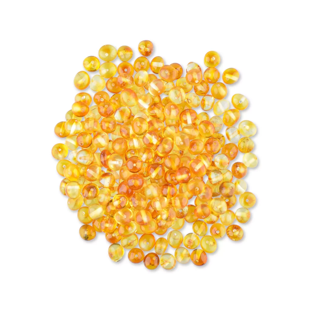 Shiny amber beads in warm honey tones, showcasing natural translucency and smooth, rounded shapes.