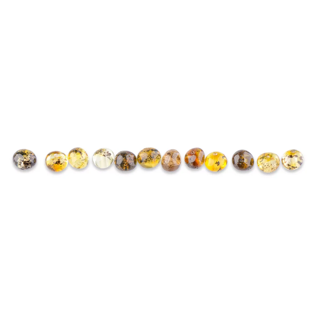 Line of polished amber beads showcasing natural colors and unique internal inclusions.