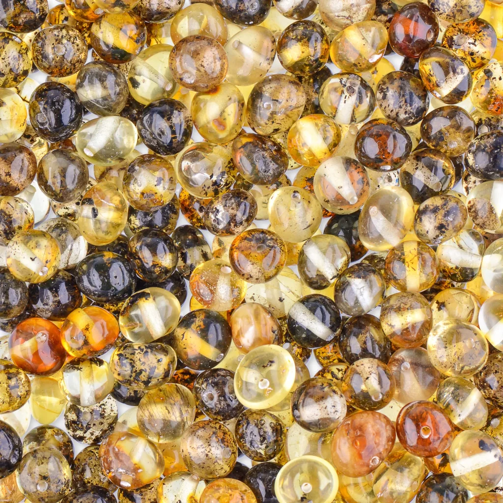 Vibrant polished Baltic amber beads with natural inclusions, warm hues, and a glossy, reflective surface.