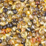 Vibrant polished Baltic amber beads with natural inclusions, warm hues, and a glossy, reflective surface.