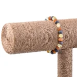 Colorful beaded bracelet on natural sisal scratching post for cats and home decor accents.