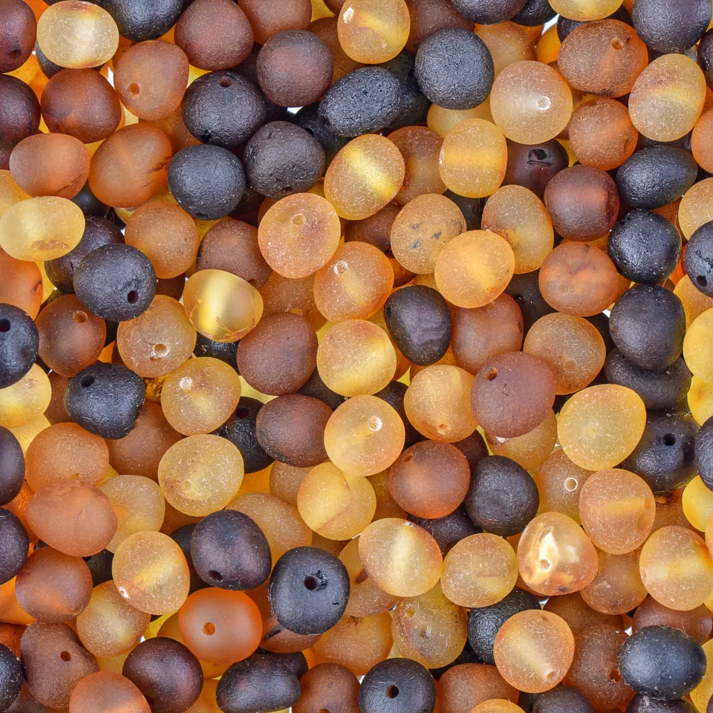 Colorful Baltic amber beads for jewelry, featuring smooth, matte, and translucent finishes.