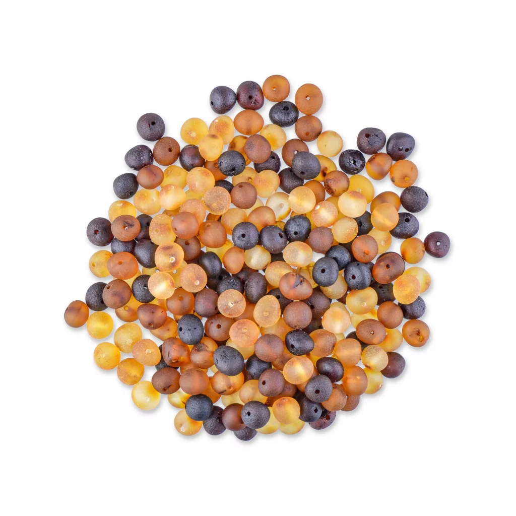 Colorful polished Baltic amber beads scattered, showcasing vibrant hues and smooth, glossy textures.