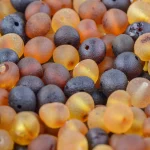 Colorful seed beads and amber fragments with glossy, translucent, natural organic appearance.