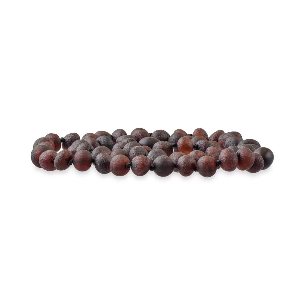 Close-up of glossy dark purple seeds arranged in a neat line, highlighting their smooth, natural texture.
