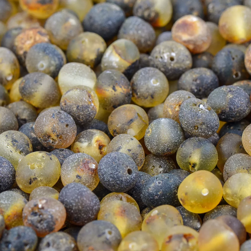 Colorful glass beads with varied textures and organic imperfections, creating a vibrant, handcrafted jewelry aesthetic.