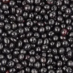 Close-up of glossy black berry-inspired Baltic amber beads on a handmade necklace.