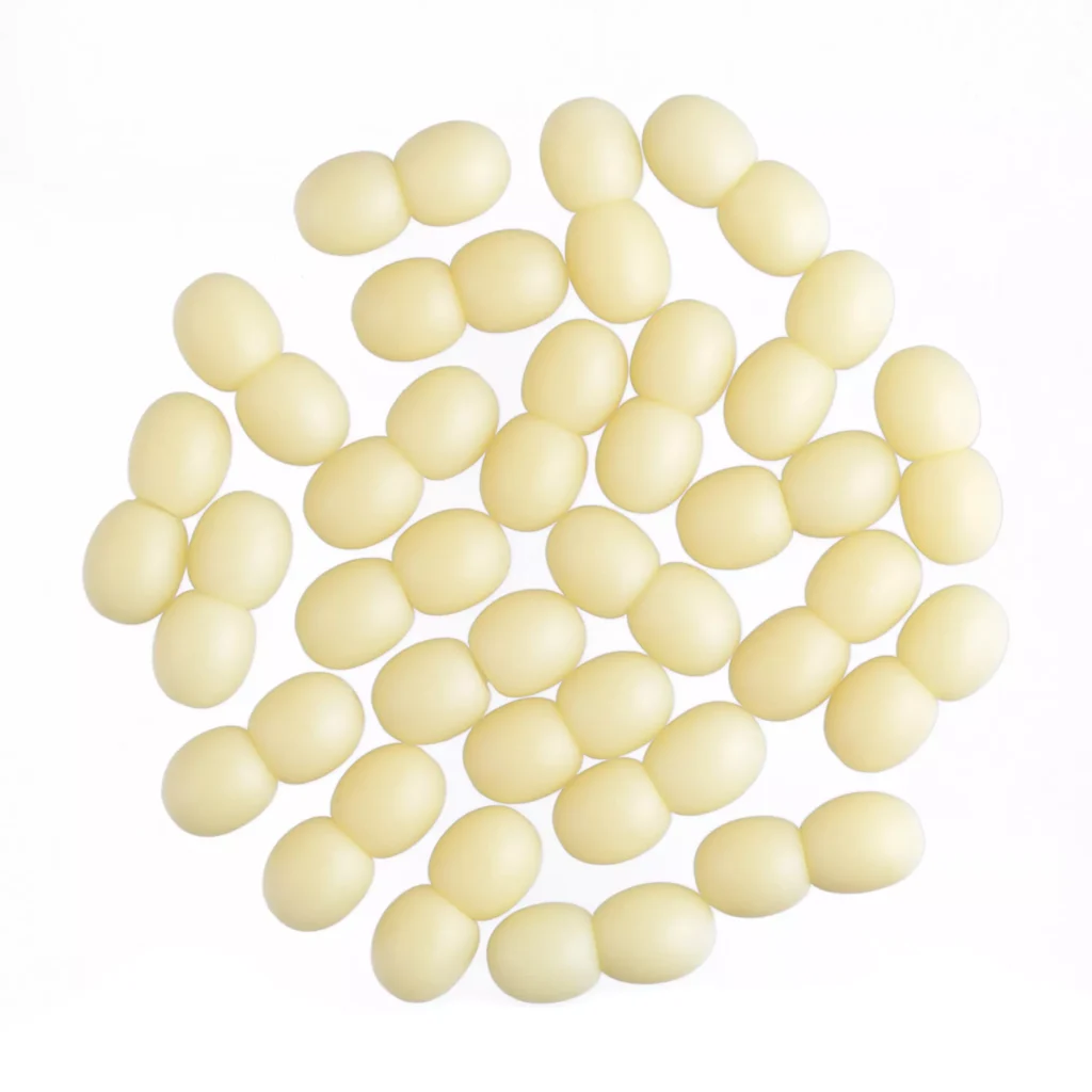 Group of pale yellow oval amber beads arranged symmetrically on a white background.