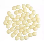 Group of pale yellow oval amber beads arranged symmetrically on a white background.