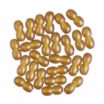 Golden oval capsules in a dense, shiny cluster with reflective, luxurious appearance.