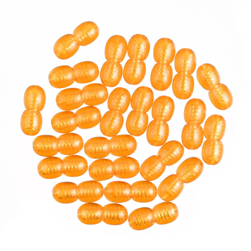 Array of shiny orange oval beads arranged in a circular pattern on a white background.
