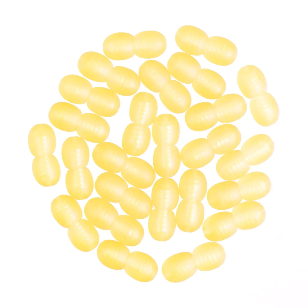 Collection of yellow oval pills or candies with glossy, two-lobed shapes and cheerful appearance.