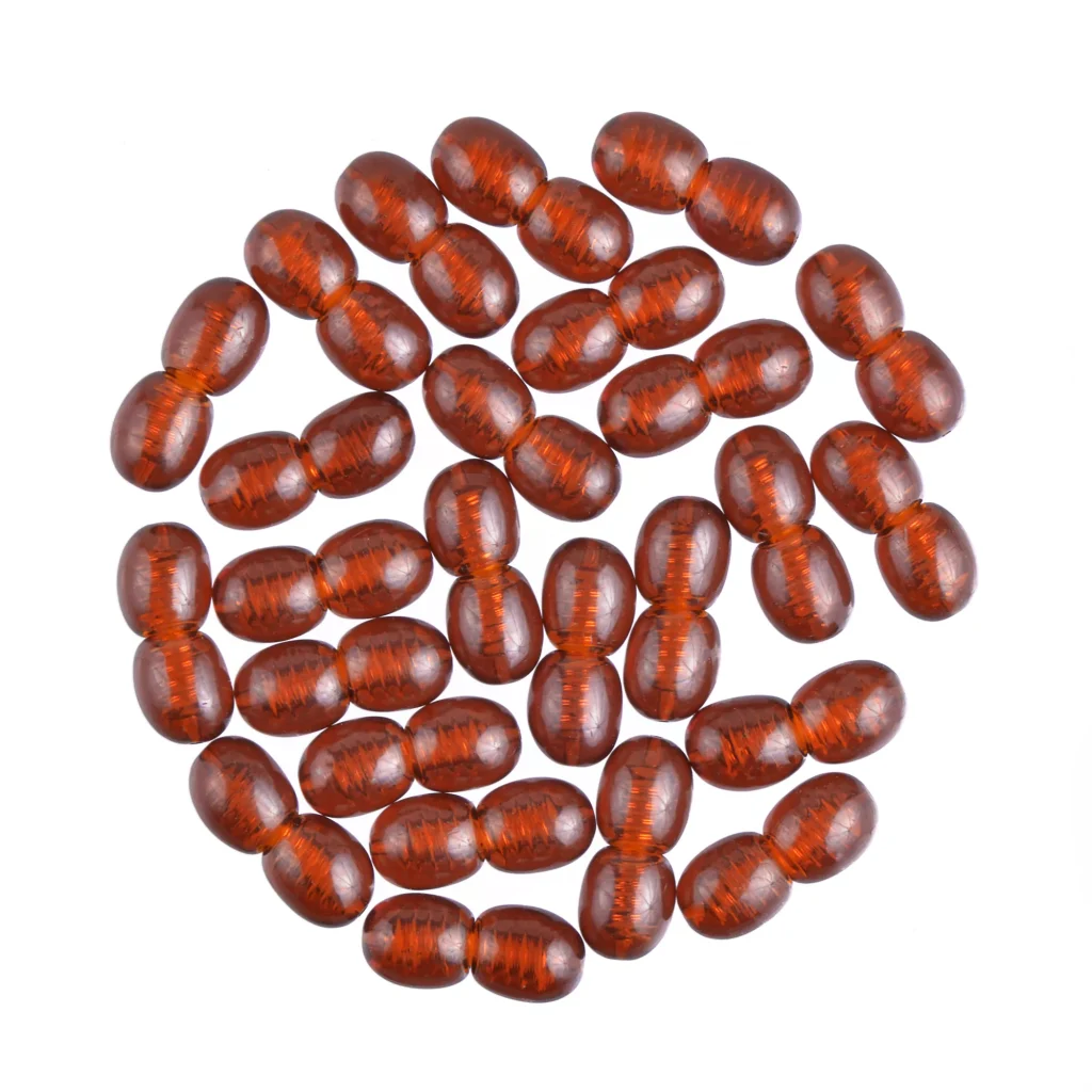 Collection of glossy reddish-brown oval Baltic amber beads arranged in a circular pattern.