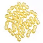 Collection of glossy yellow oval capsules with ribbed texture on white background.