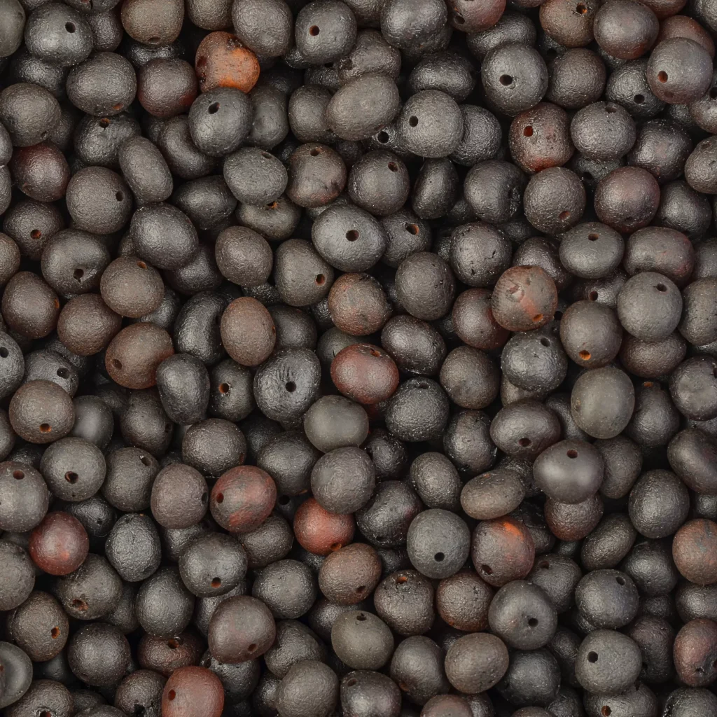 Close-up of dark and light seed-textured Baltic amber beads with organic, natural appearance.