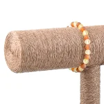 Colorful beaded bracelet on textured sisal cat scratching post, blending style and function.