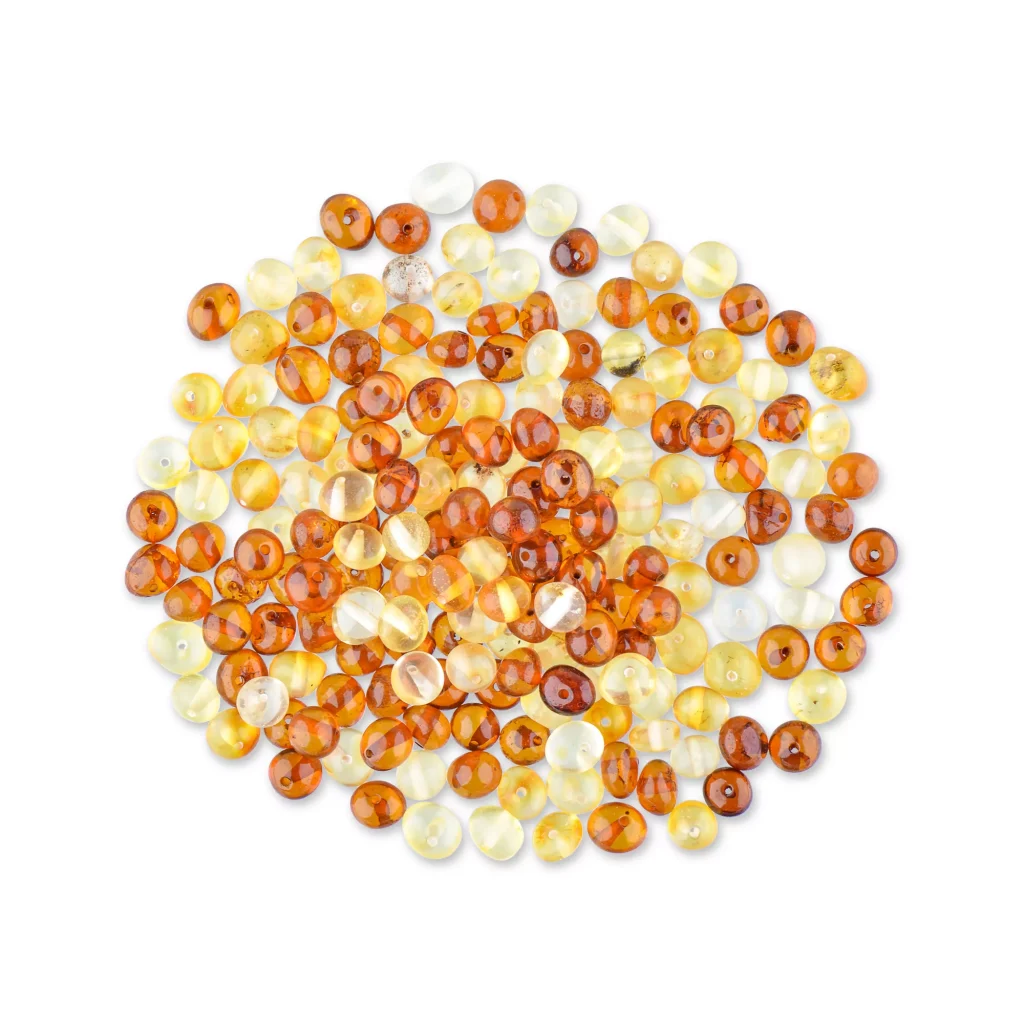 Colorful glass and amber beads scattered, showcasing warm tones and polished, artisanal craftsmanship.