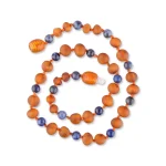 Handmade Baltic amber necklace with blue beads, natural warm cognac hues, and artisanal craftsmanship.