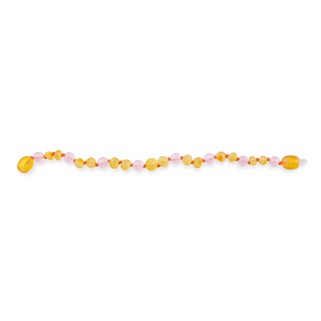 Beaded necklace with yellow and pink oval and translucent round beads on white background.
