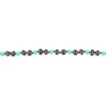 Black glossy beads with vibrant turquoise accents in a stylish handcrafted jewelry piece.