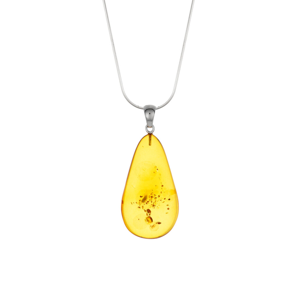 A close-up image of a genuine amber pendant showcasing its warm, golden hues. The amber is transparent with natural inclusions, capturing its organic beauty. The pendant is encased in a silver or gold frame, adding elegance to the raw, fossilized resin. The smooth surface of the amber reflects light, highlighting its natural glow and intricate details. This timeless piece of jewelry hangs delicately from a chain, blending nature and craftsmanship.