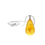 A close-up image of a genuine amber pendant showcasing its warm, golden hues. The amber is transparent with natural inclusions, capturing its organic beauty. The pendant is encased in a silver or gold frame, adding elegance to the raw, fossilized resin. The smooth surface of the amber reflects light, highlighting its natural glow and intricate details. This timeless piece of jewelry hangs delicately from a chain, blending nature and craftsmanship.