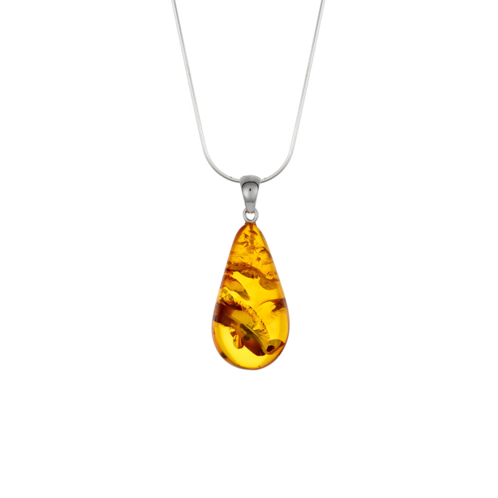 A close-up image of a genuine amber pendant showcasing its warm, golden hues. The amber is transparent with natural inclusions, capturing its organic beauty. The pendant is encased in a silver or gold frame, adding elegance to the raw, fossilized resin. The smooth surface of the amber reflects light, highlighting its natural glow and intricate details. This timeless piece of jewelry hangs delicately from a chain, blending nature and craftsmanship.