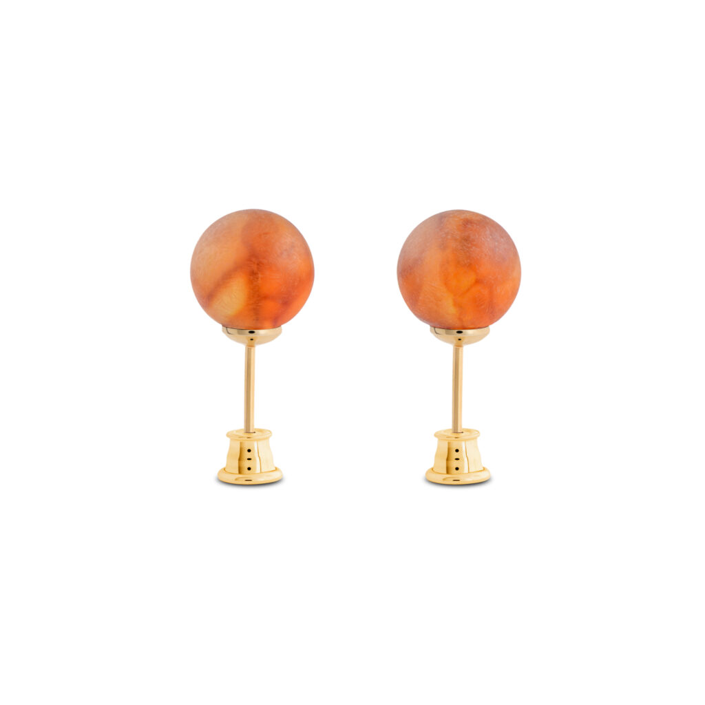 Close-up image of a pair of genuine amber earrings, showcasing their warm, golden-orange hue with natural inclusions. The earrings have a smooth, polished surface, highlighting the organic beauty of the amber, set in simple yet elegant silver clasps. The intricate details of the fossilized resin are visible, giving each piece a unique and timeless appeal.