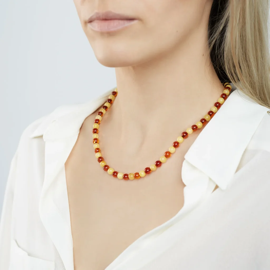 Close-up image of genuine amber jewelry, featuring warm golden hues with natural inclusions inside the translucent gemstone. The amber is polished and set in silver, highlighting its organic beauty. Each piece has unique imperfections, reflecting its natural origin from fossilized tree resin.