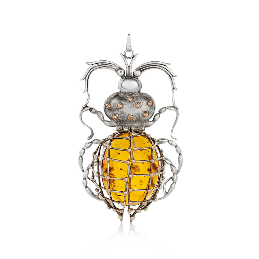 Sterling silver and gold beetle pendant with a large amber stone, showcasing intricate craftsmanship and natural inclusions