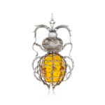 Sterling silver and gold beetle pendant with a large amber stone, showcasing intricate craftsmanship and natural inclusions