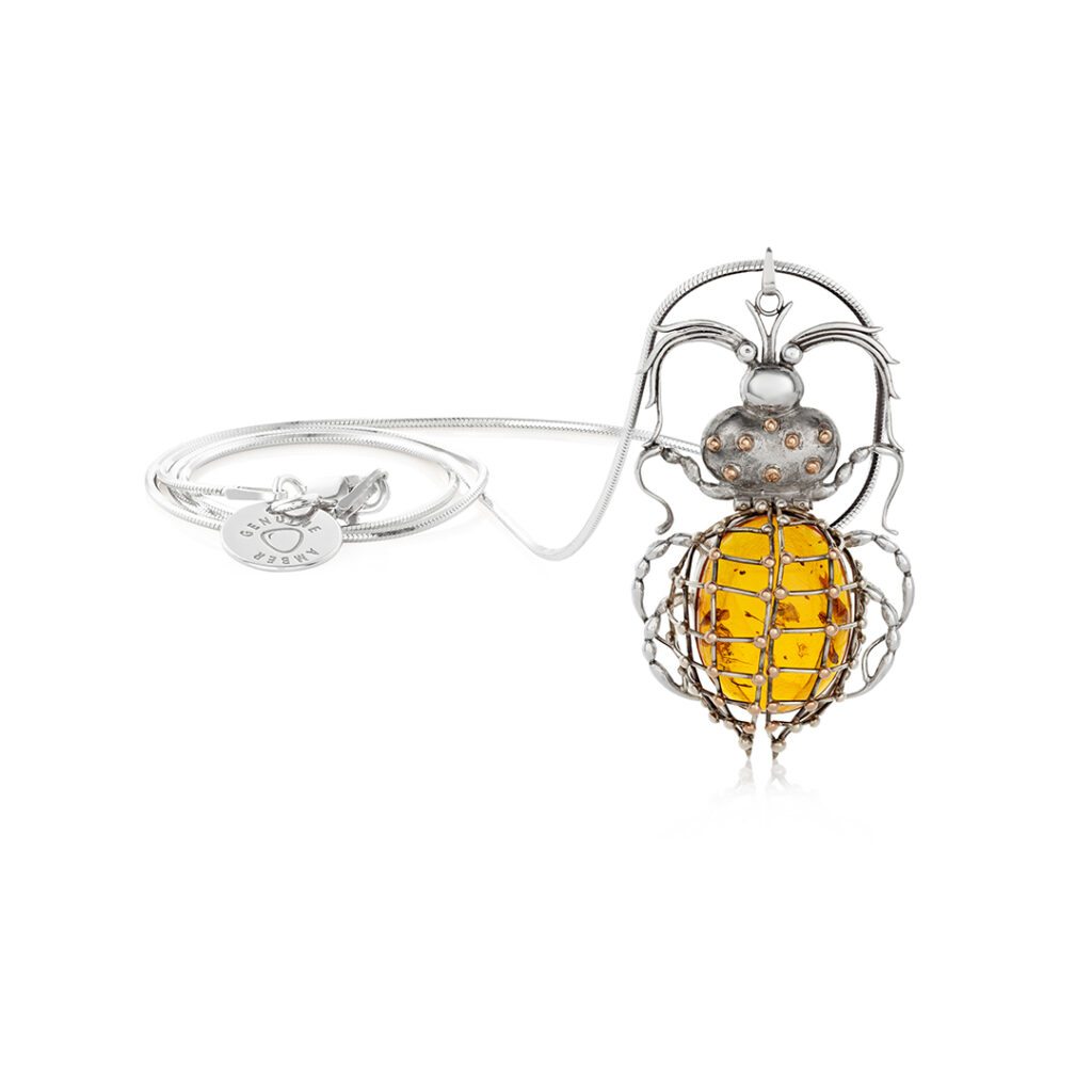 Sterling silver and gold beetle pendant with a large amber stone, showcasing intricate craftsmanship and natural inclusions