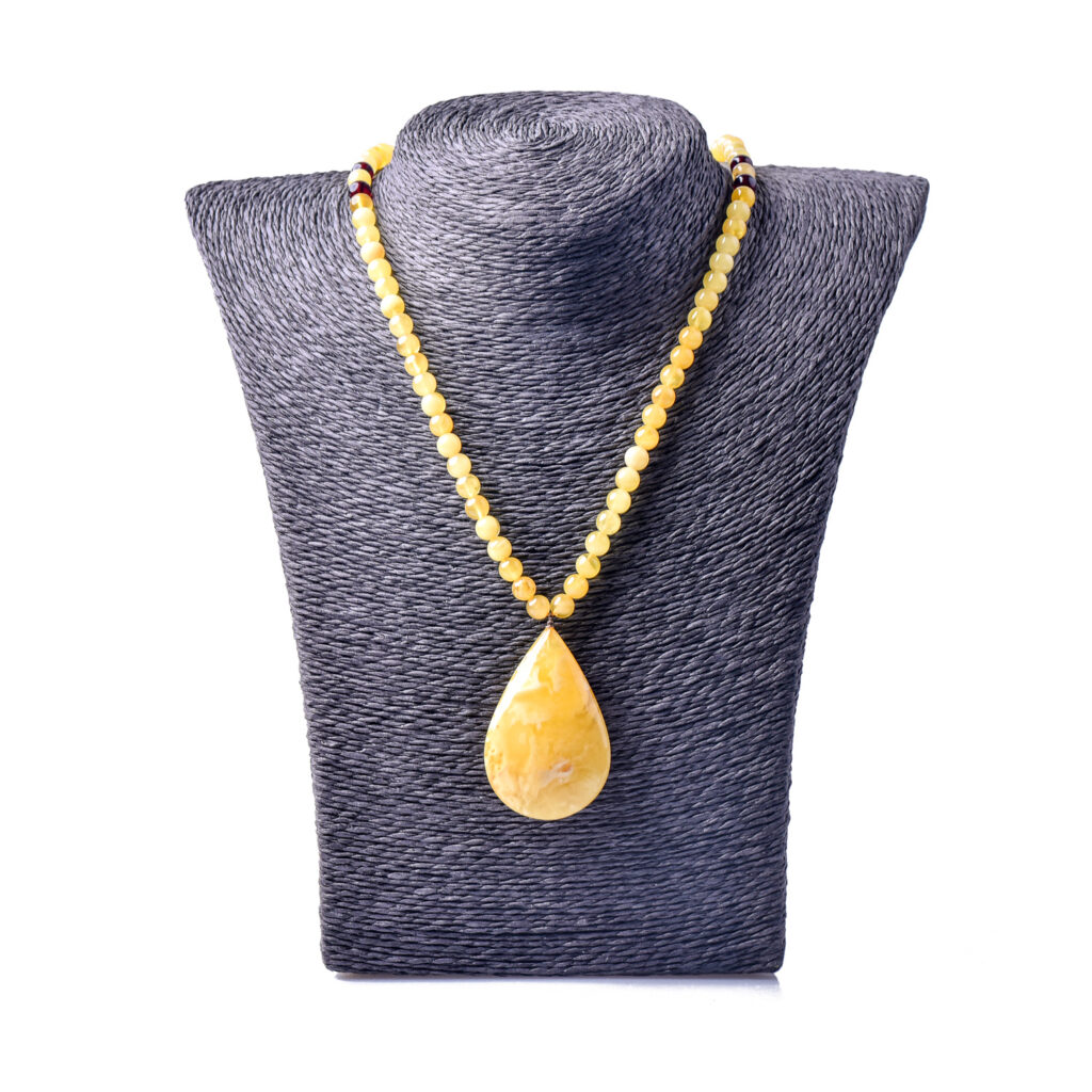 A genuine amber necklace featuring butter-colored beads with a soft, creamy yellow tone. The beads are smooth and slightly translucent, with delicate inclusions that highlight the natural origin of the amber. The necklace exudes a warm, gentle glow, showcasing the unique and organic beauty of the butter-colored amber.