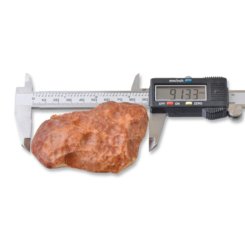 The raw amber piece shown with a ruler for scale, illustrating its impressive size and collectible nature.