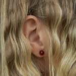 natural amber errings studs. In the woman's ear.