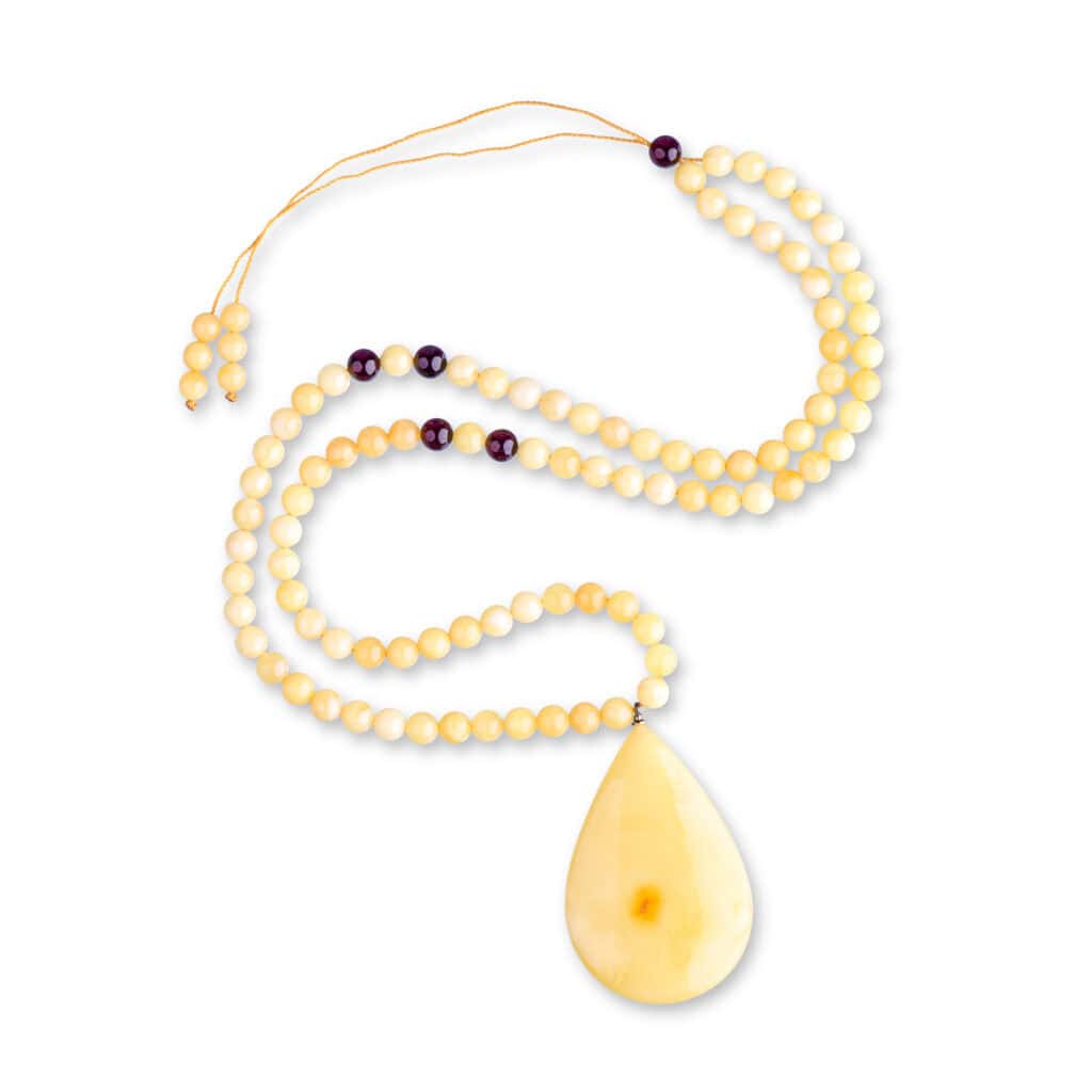 Elegant cream and dark Baltic amber necklace with teardrop pendant for versatile style.