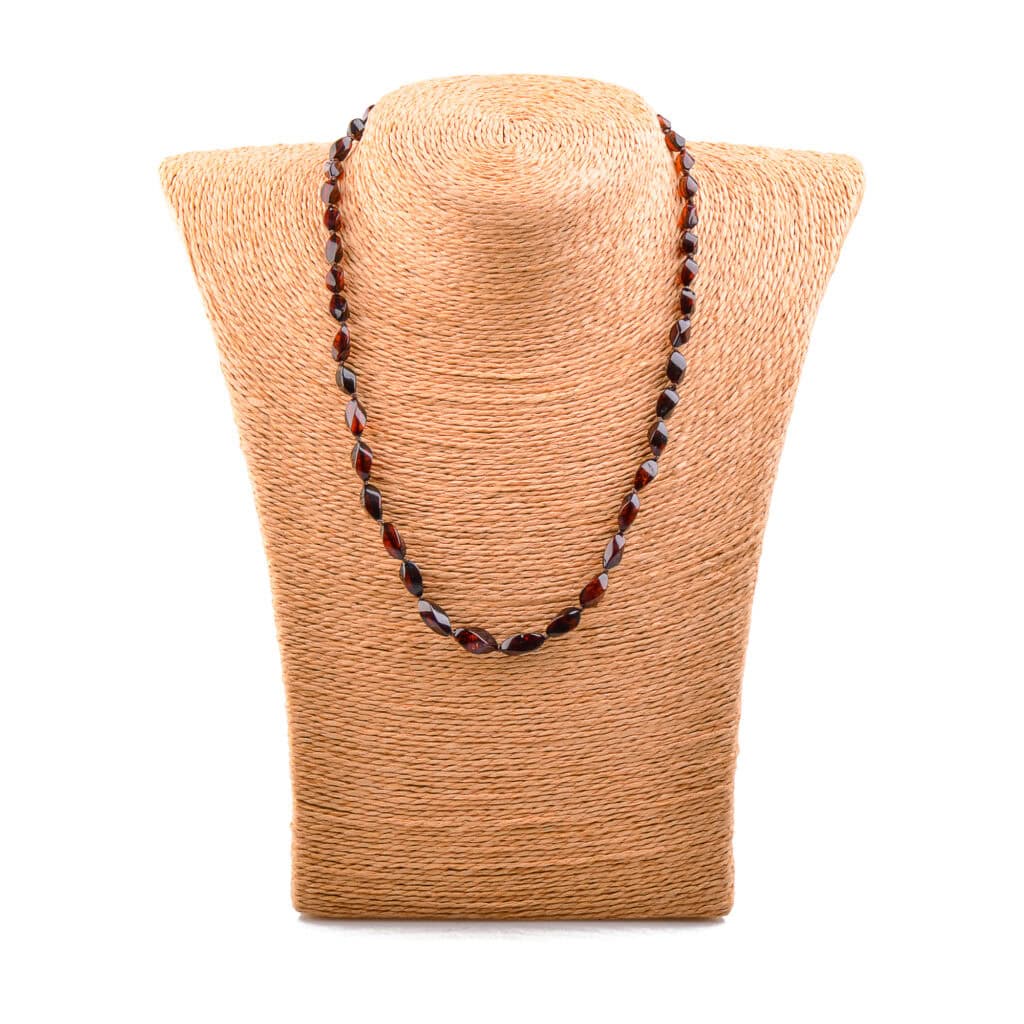 Handmade Baltic amber necklace with earthy, varied-shaped beads on textured bust display.